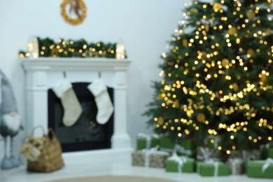 Photo of Blurred view of cozy living room with fireplace and Christmas tree. Interior design
