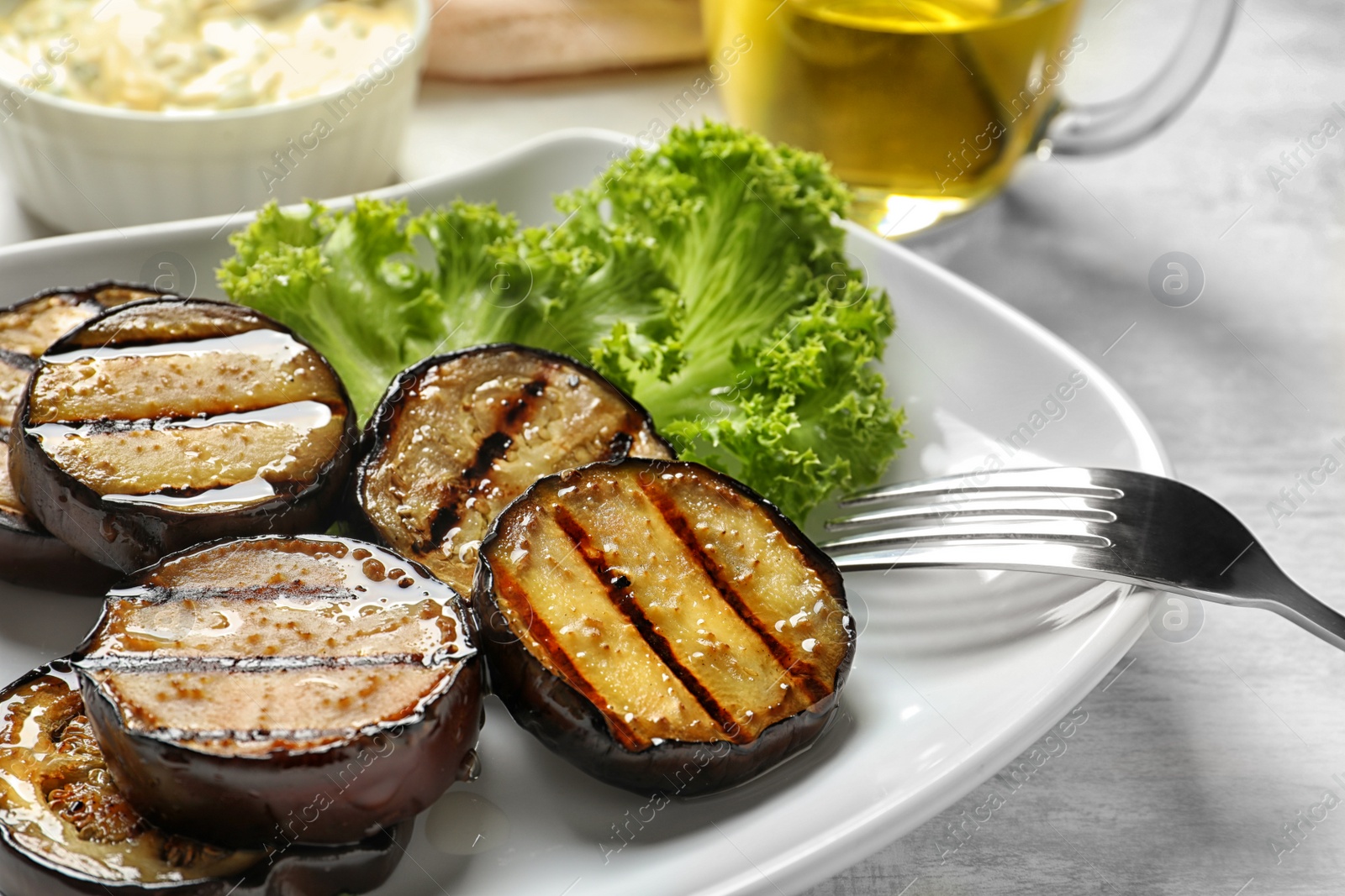 Photo of Plate with fried eggplant slices on table, closeup