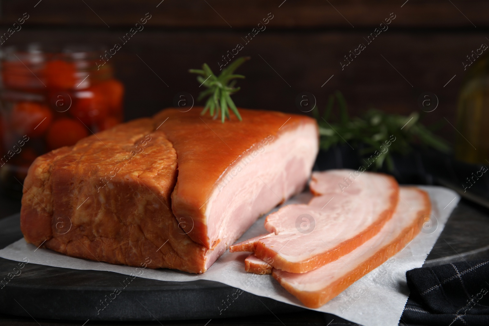 Photo of Delicious smoked bacon with rosemary on board, closeup