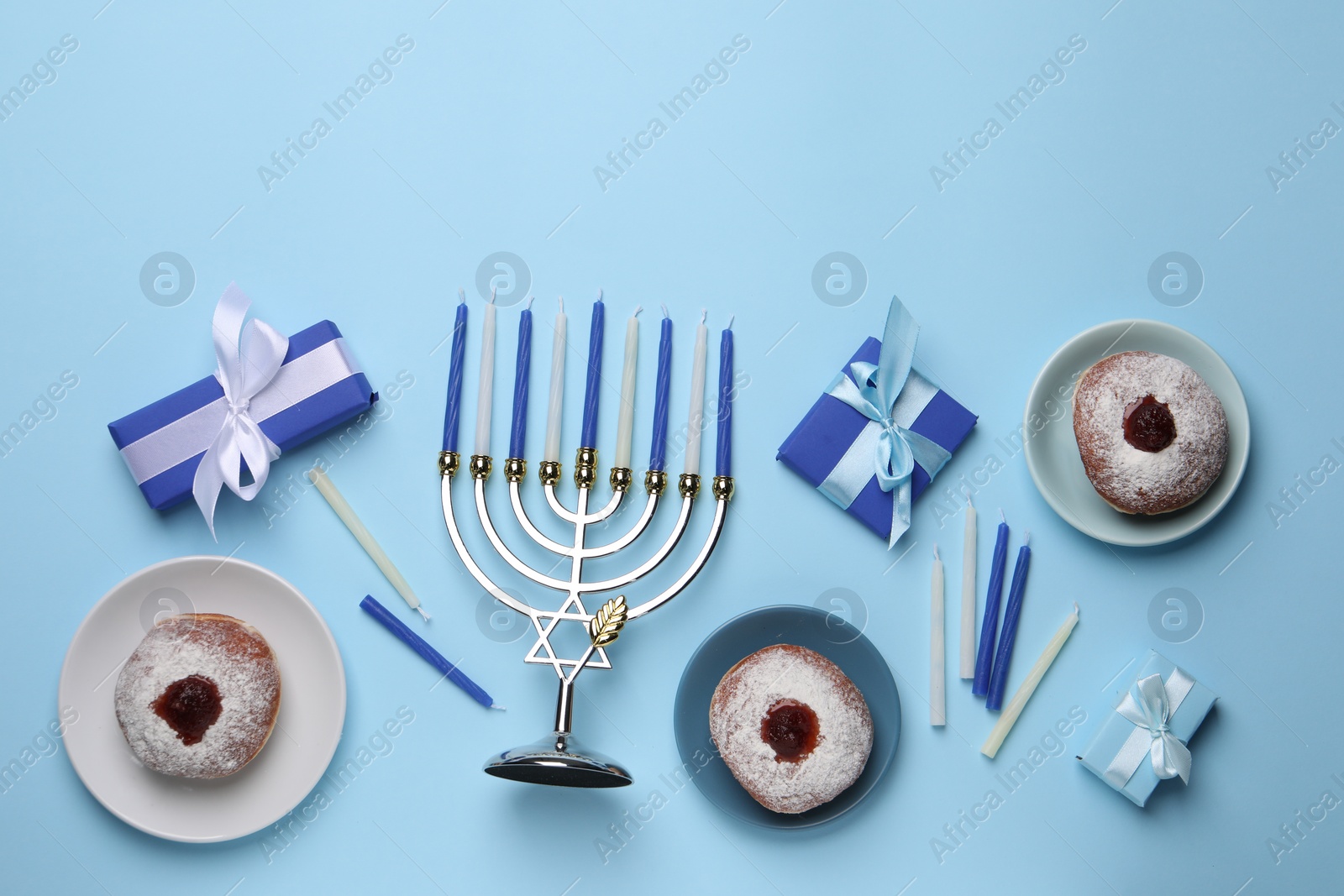 Photo of Flat lay composition with Hanukkah menorah and donuts on light blue background