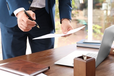 Photo of Lawyer working with documents at table, focus on hands