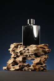 Luxury men`s perfume in bottle on grey table against dark background