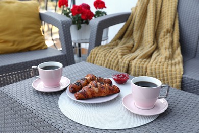 Outdoor breakfast with tea and croissants on white table on terrace