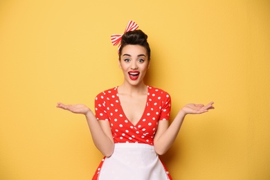 Photo of Portrait of funny young housewife on color background