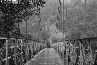 Image of Metal bridge over river in mountains, toned in black and white