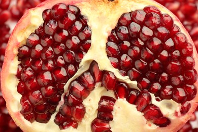 Photo of Ripe juicy red pomegranate on grains grains, top view