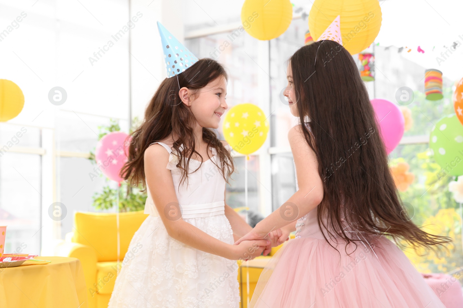 Photo of Cute girls playing together at birthday party indoors