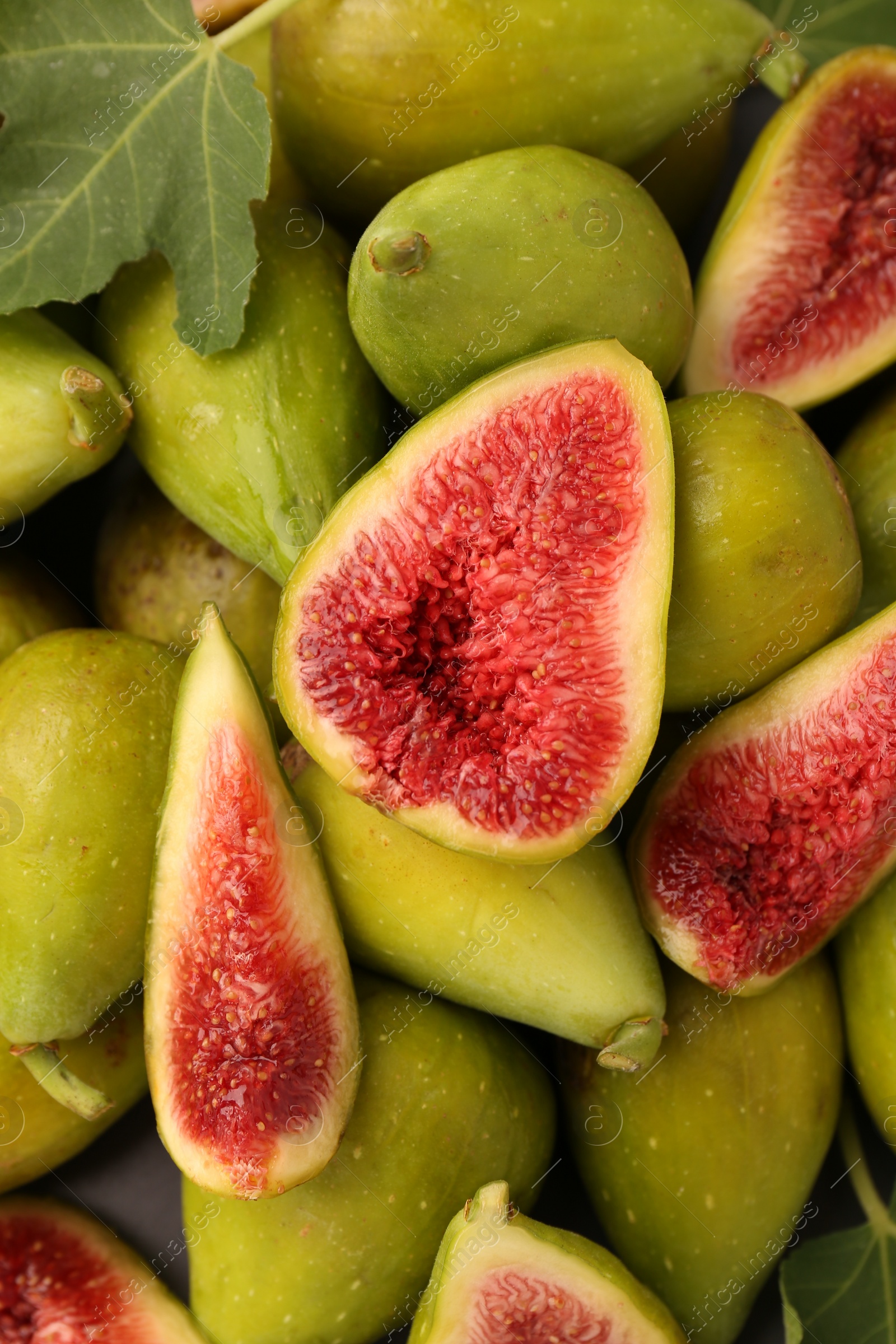 Photo of Cut and whole green figs on as background, top view.