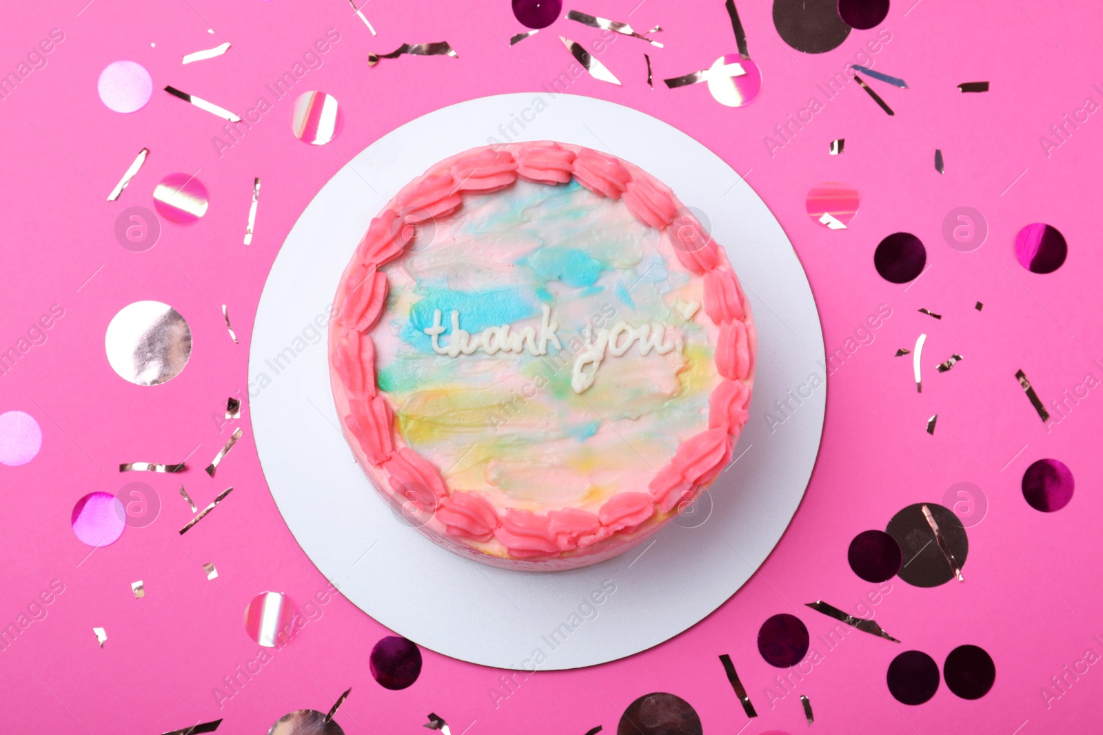 Photo of Cute bento cake with tasty cream and confetti on pink background, flat lay
