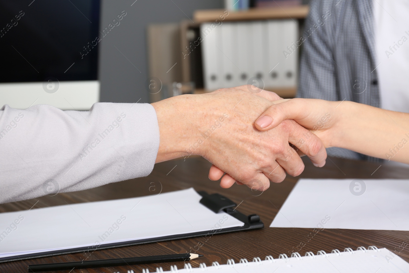 Photo of Lawyer shaking hands with client in office, closeup