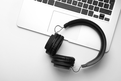 Photo of Modern headphones and laptop on white background, top view