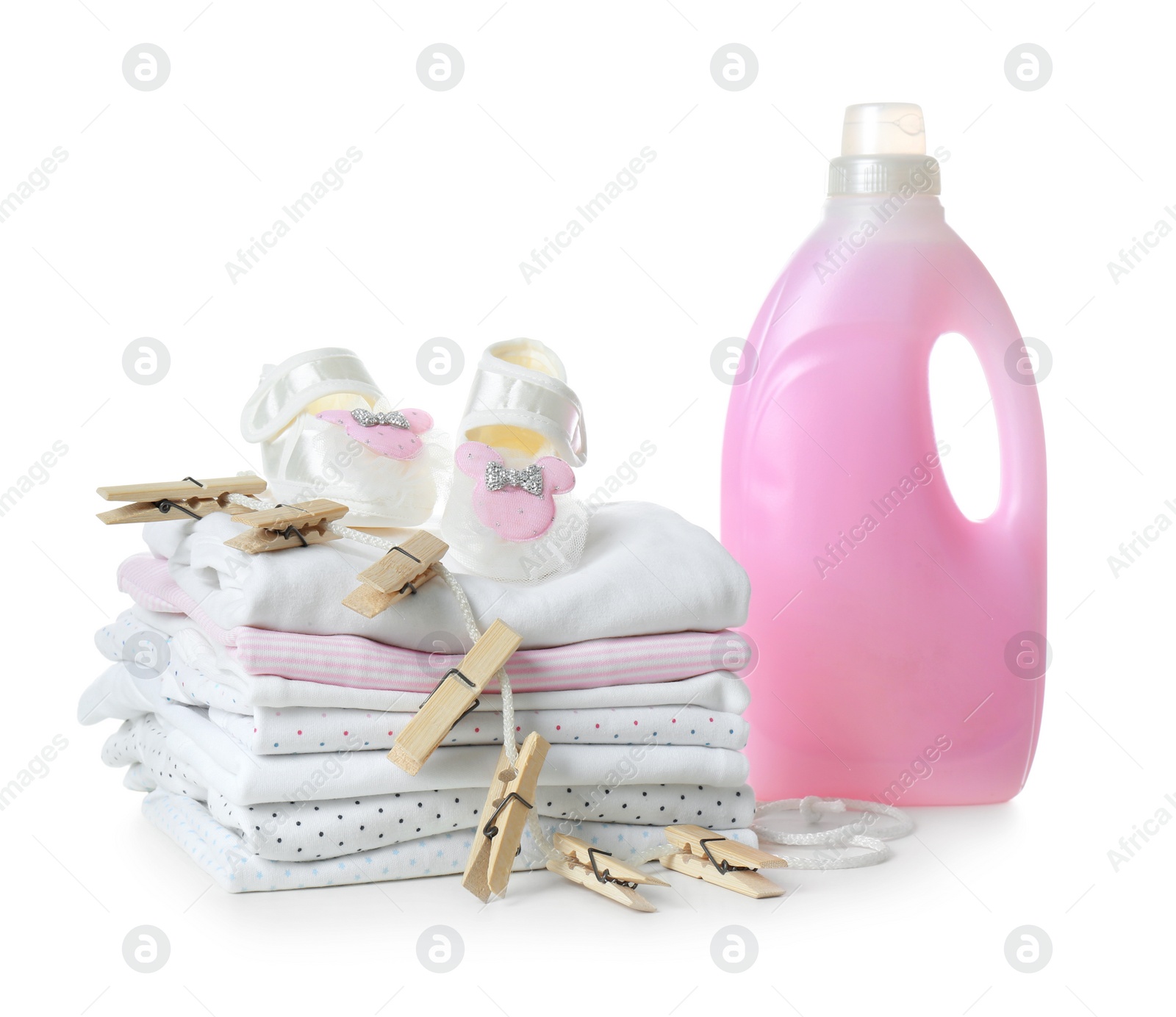 Photo of Fresh baby laundry and bottle of detergent on white background