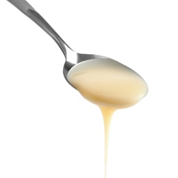 Photo of Spoon with condensed milk on white background, closeup. Dairy product