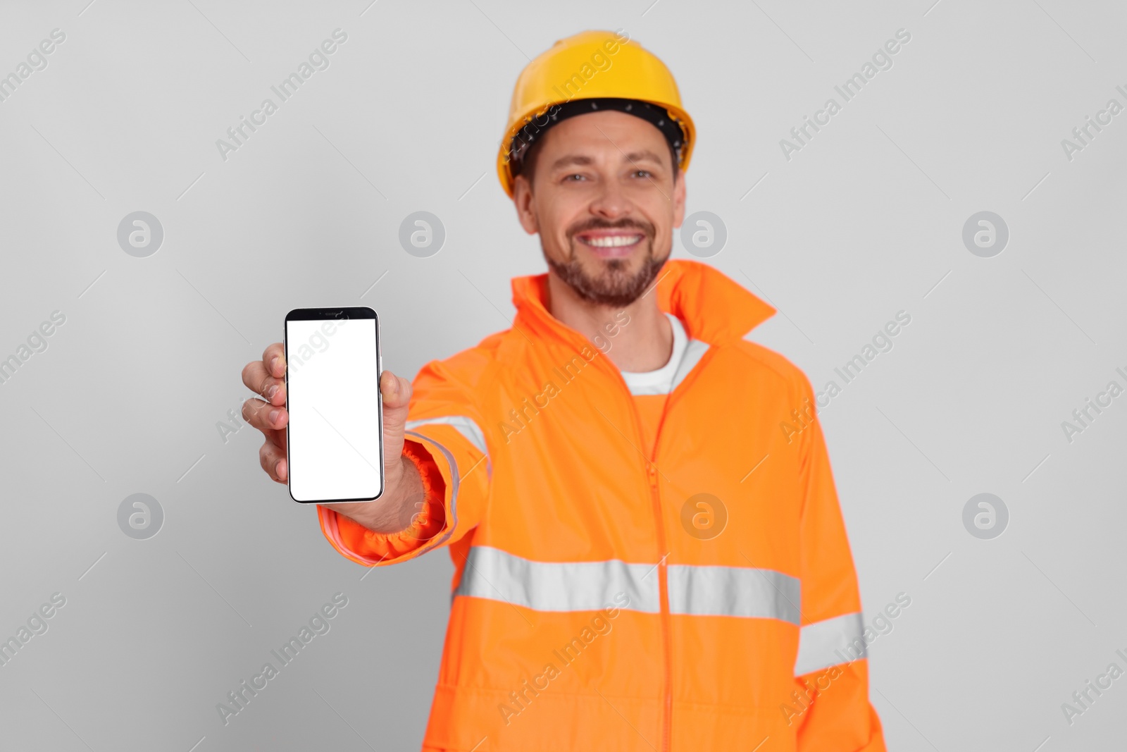 Photo of Man in reflective uniform with phone on white background