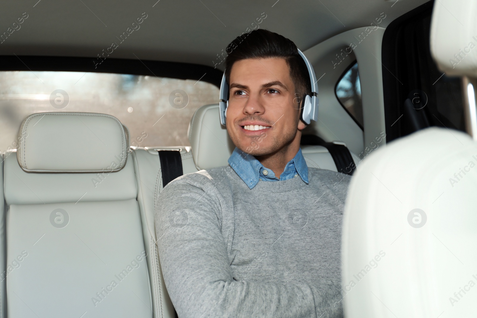 Photo of Handsome man listening to audiobook in car