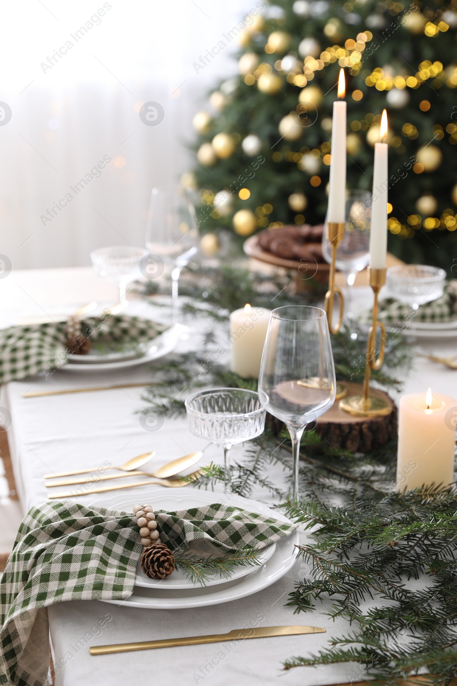 Photo of Christmas table setting with festive decor and dishware indoors