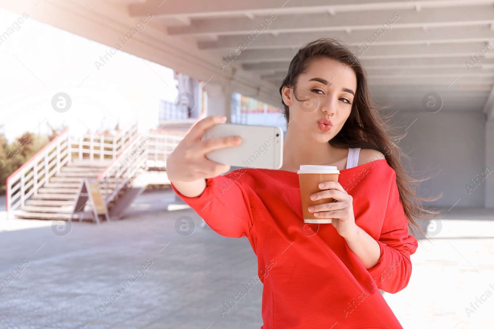 Photo of Attractive young woman taking selfie with phone outdoors