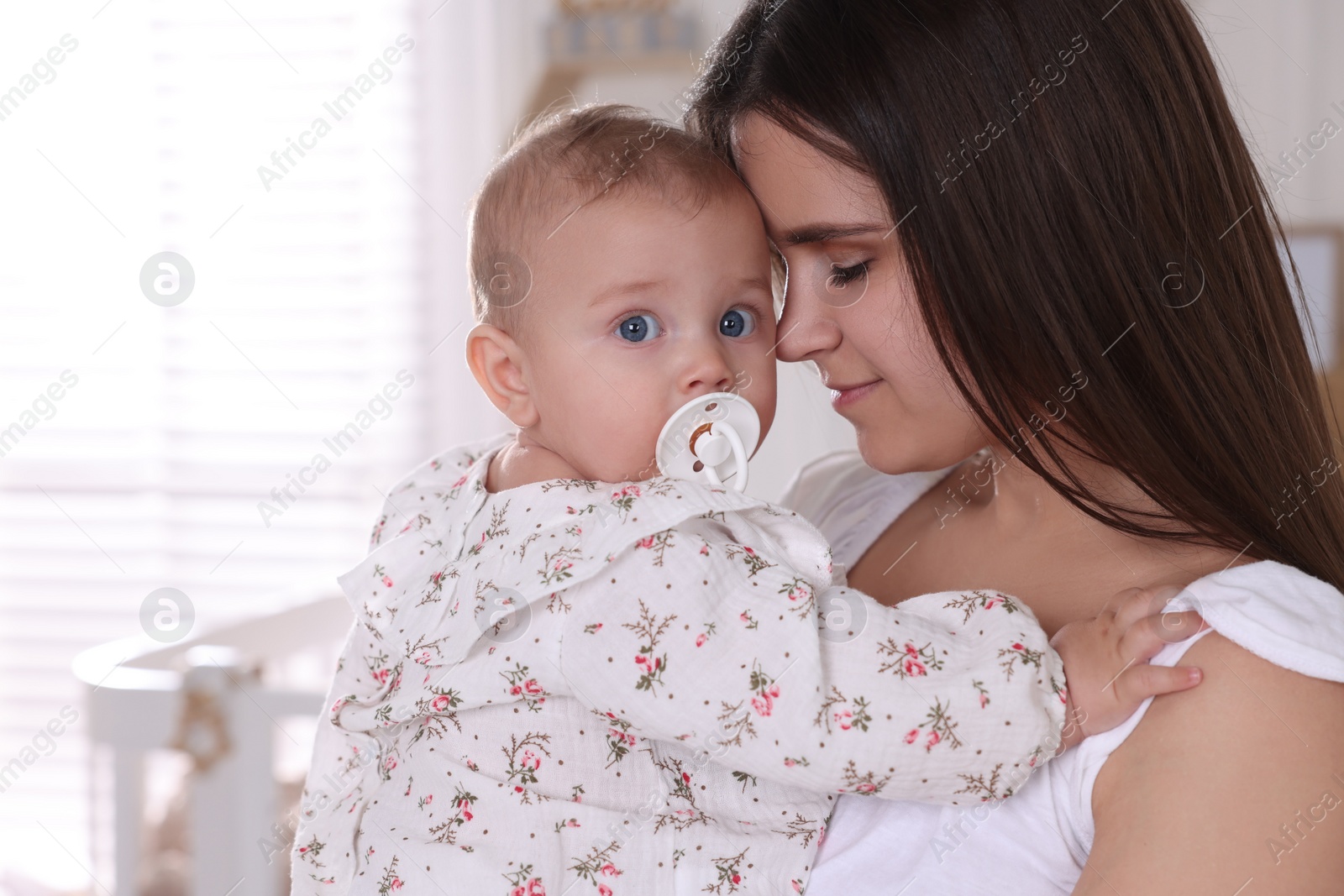 Photo of Happy young mother with her baby daughter at home