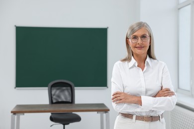 Portrait of smiling professor in classroom, space for text