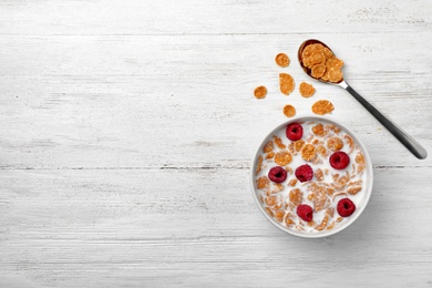 Photo of Bowl of cornflakes with milk on light table, top view with space for text