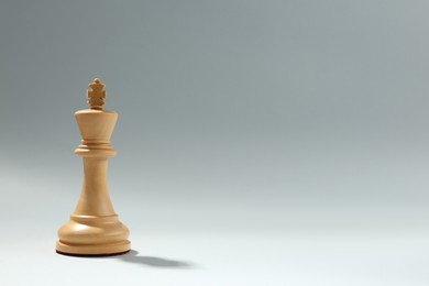 Photo of Wooden king on light background, space for text. Chess piece