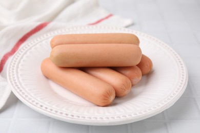 Delicious boiled sausages on white tiled table, closeup