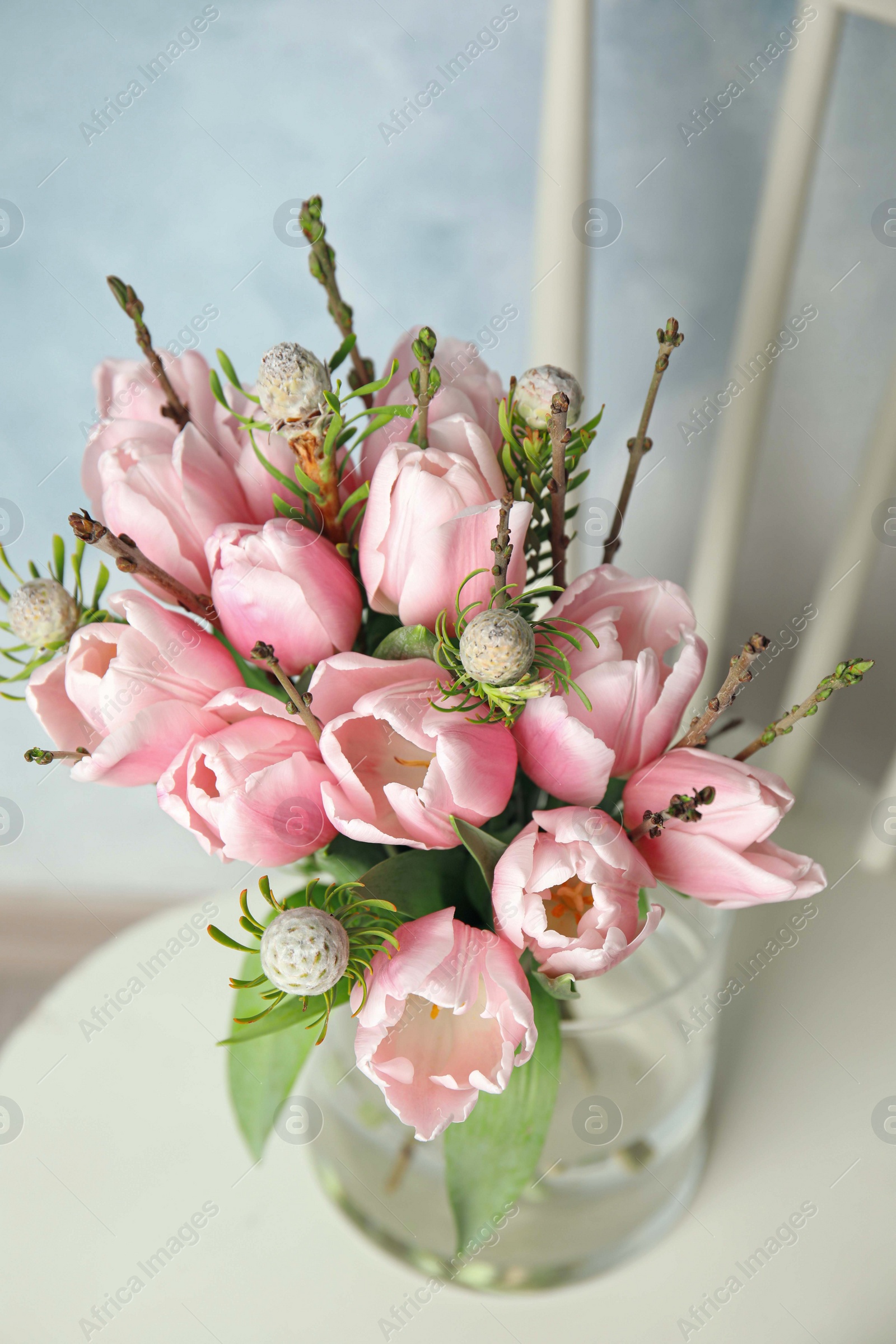 Photo of Beautiful bouquet with spring pink tulips on white chair