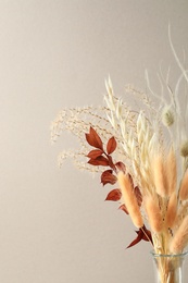 Dried flowers in vase against light background