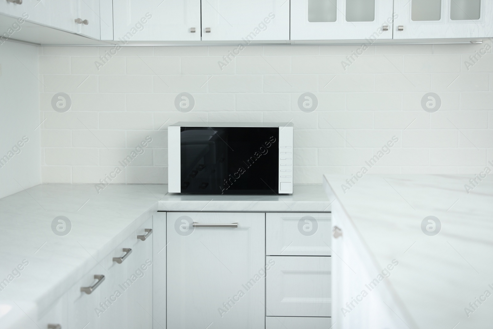 Photo of Modern microwave oven on countertop in kitchen