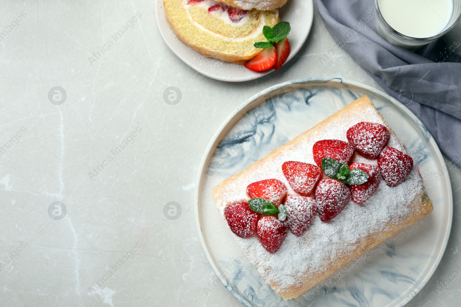 Photo of Delicious cake roll with strawberries and milk on light gray table, flat lay. Space for text