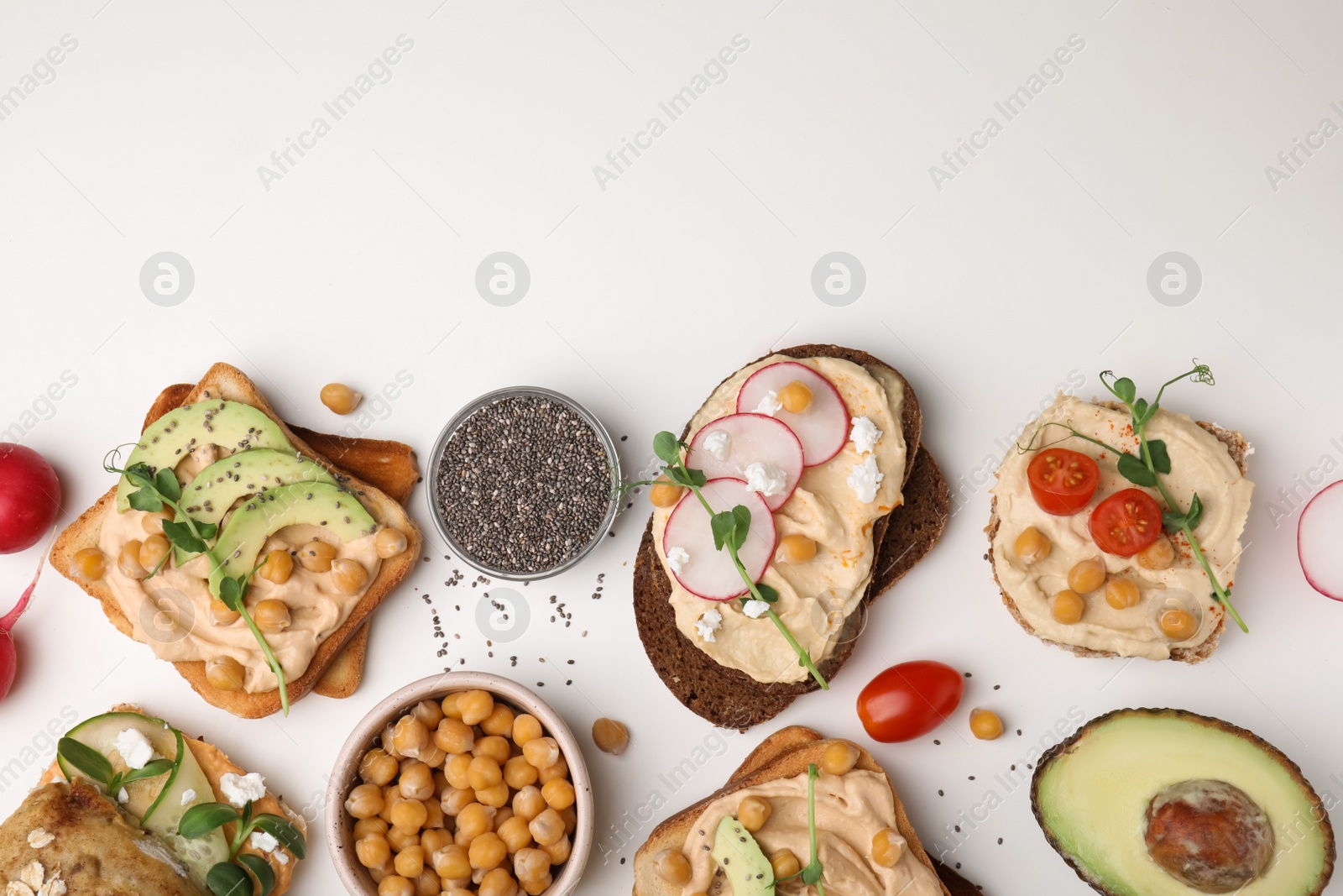 Photo of Delicious sandwiches with hummus and different ingredients on white background, flat lay. Space for text