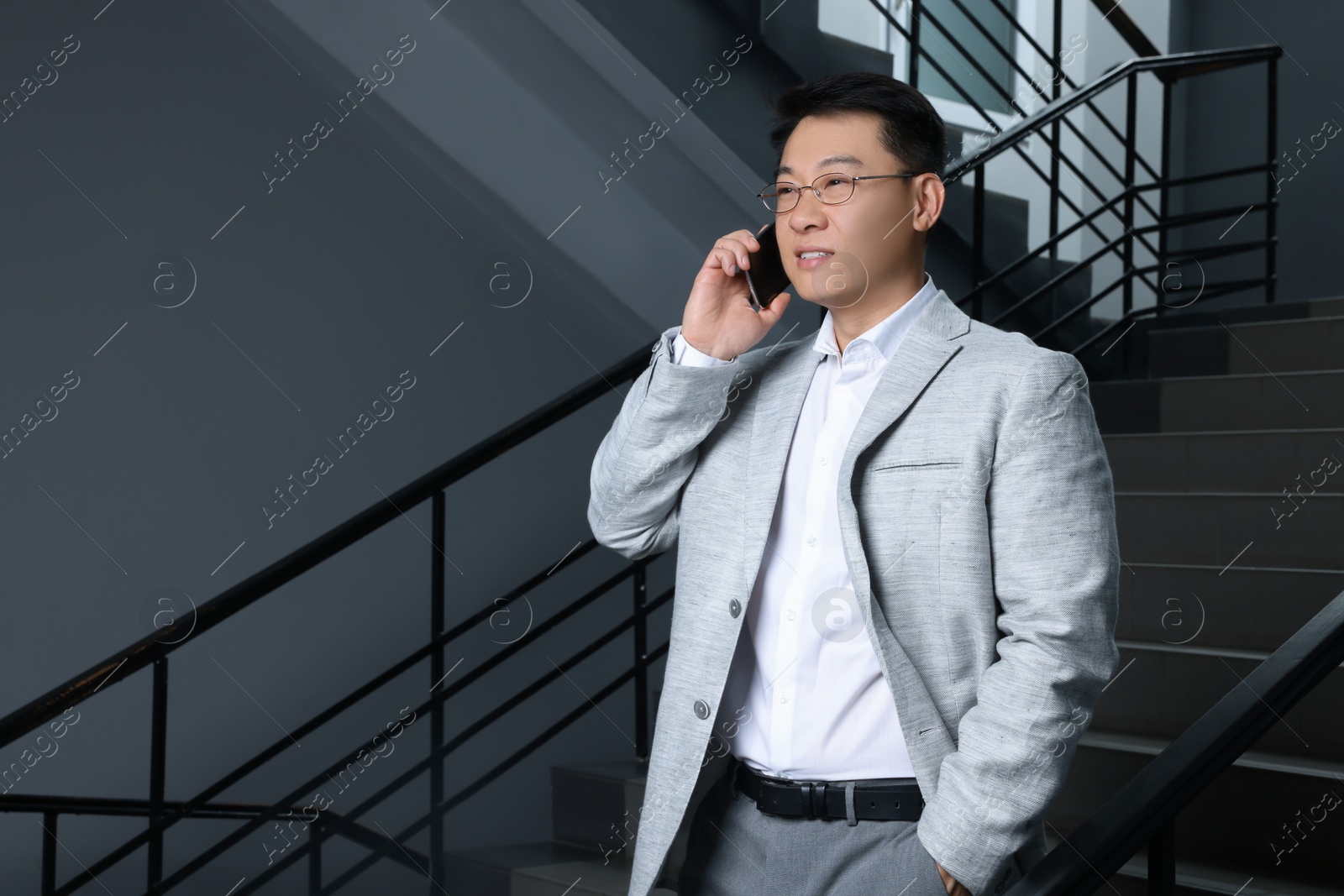 Photo of Happy boss talking on phone in office. Space for text