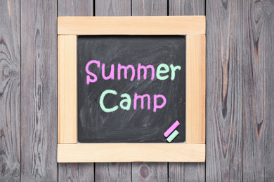 Image of Blackboard with text SUMMER CAMP on wooden background, top view
