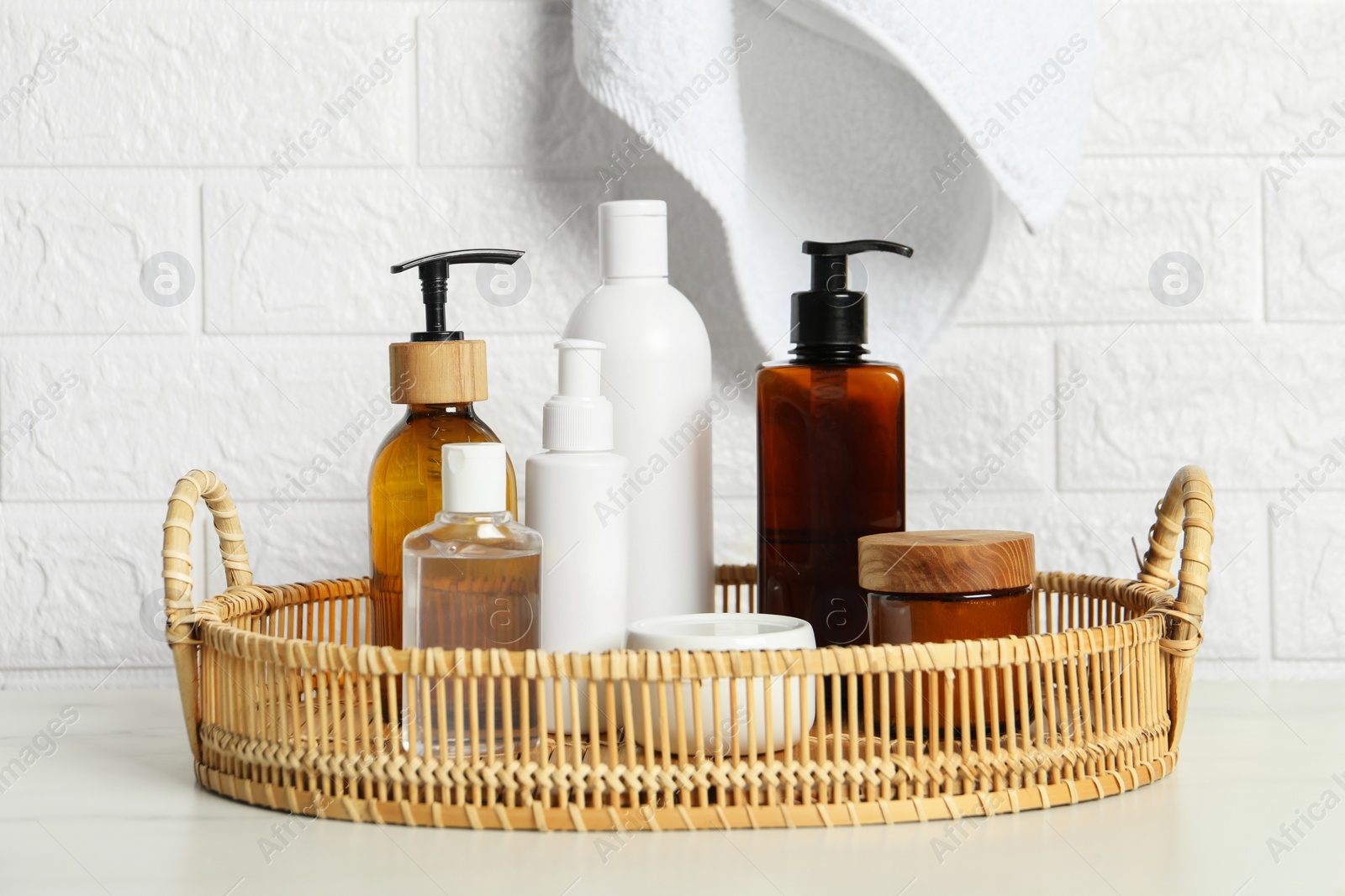 Photo of Bath accessories. Personal care products on white table near brick wall