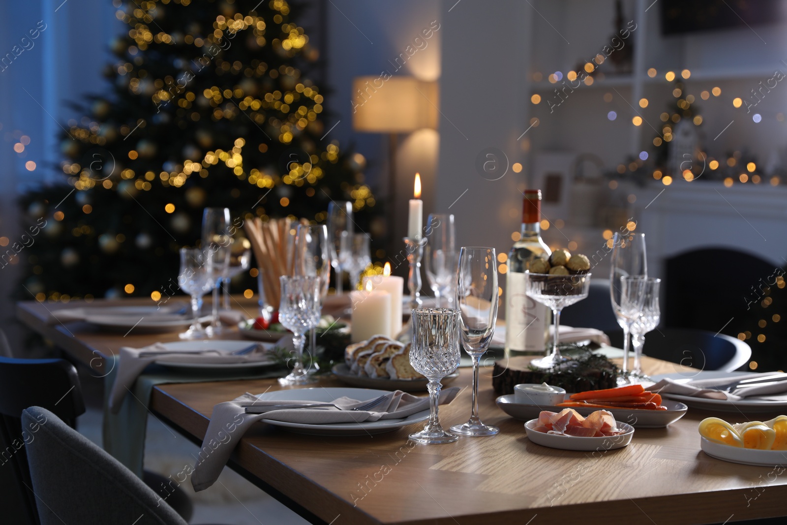 Photo of Christmas table setting with festive decor and dishware in room