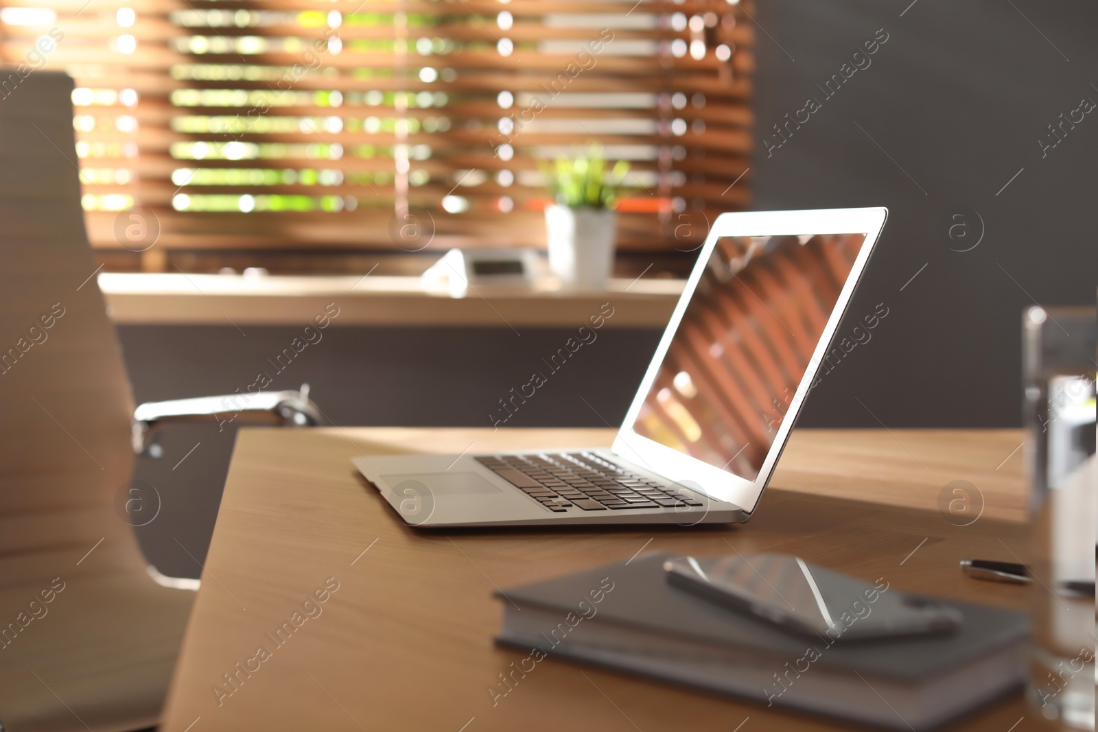 Photo of Laptop on wooden table in modern office