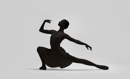 Image of Beautiful ballerina dancing on light background. Dark silhouette of dancer