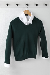 Photo of Shirt and jumper on hanger indoors. School uniform