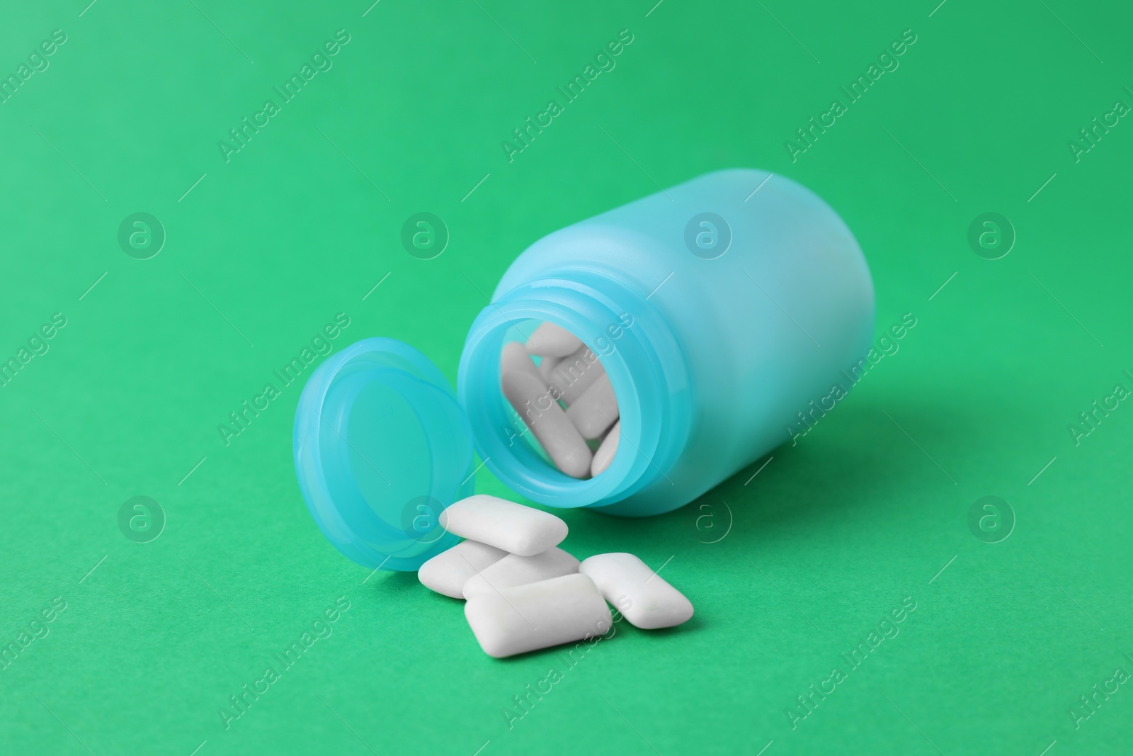 Photo of Jar with chewing gums on green background