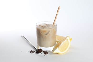 Photo of Iced coffee with milk in glass, cut lemon and instant coffee on white background