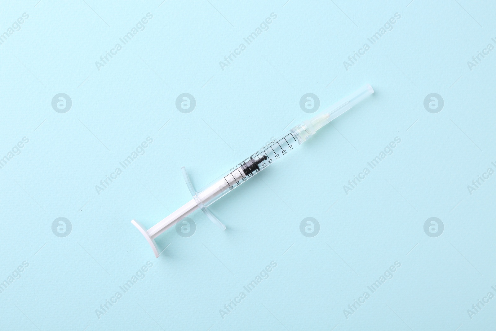 Photo of Injection cosmetology. One medical syringe on light blue background, top view