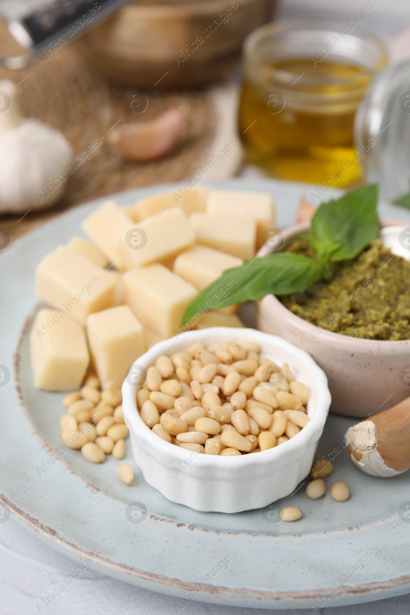 Photo of Tasty pesto sauce and ingredients on white table, closeup