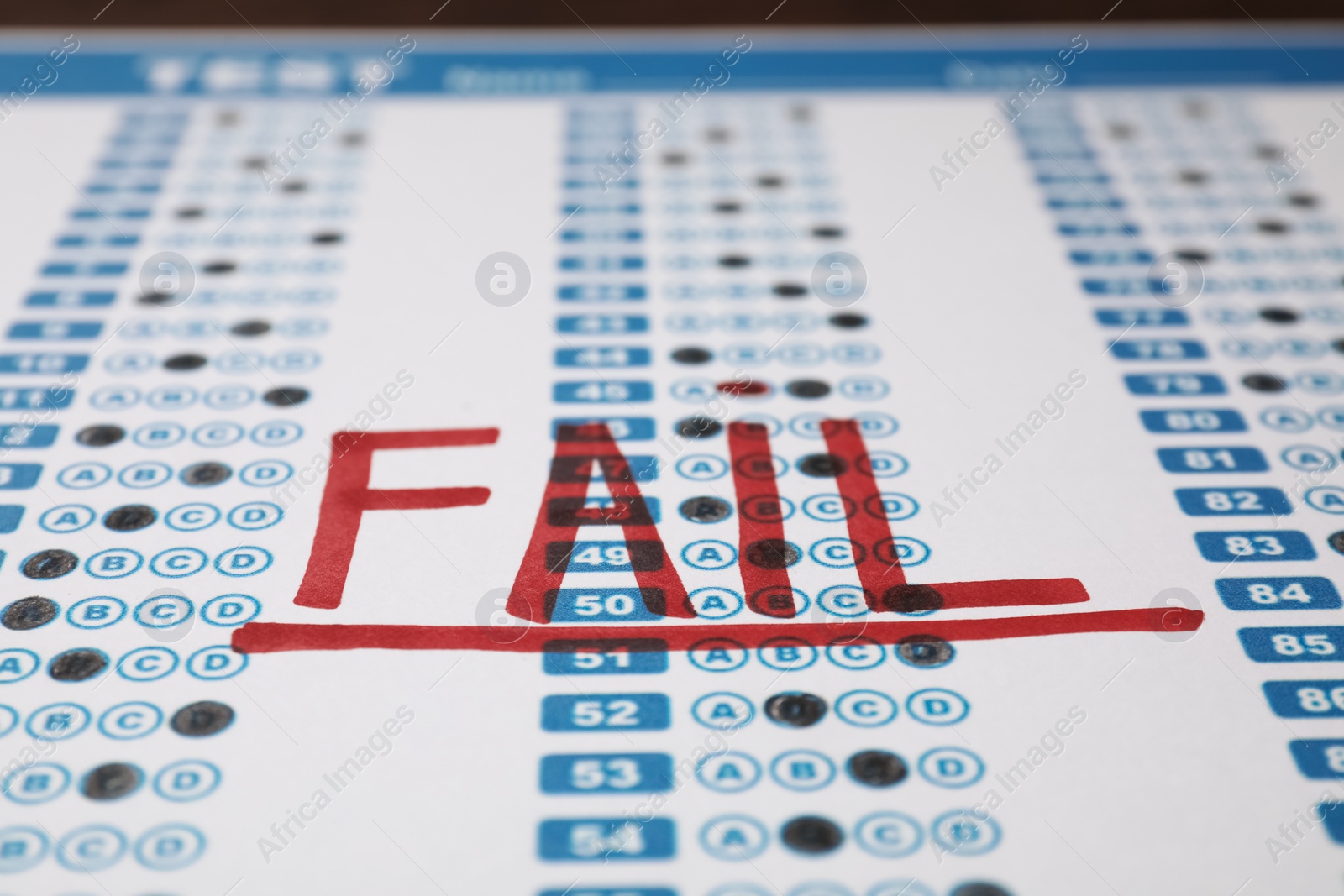 Photo of Word Fail written with red marker on answer sheet, closeup. Student passing exam