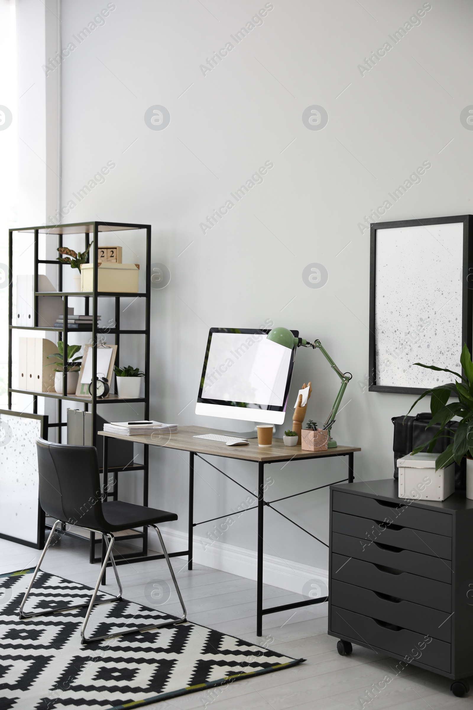 Photo of Comfortable office chair near desk with modern computer indoors