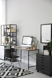 Comfortable office chair near desk with modern computer indoors