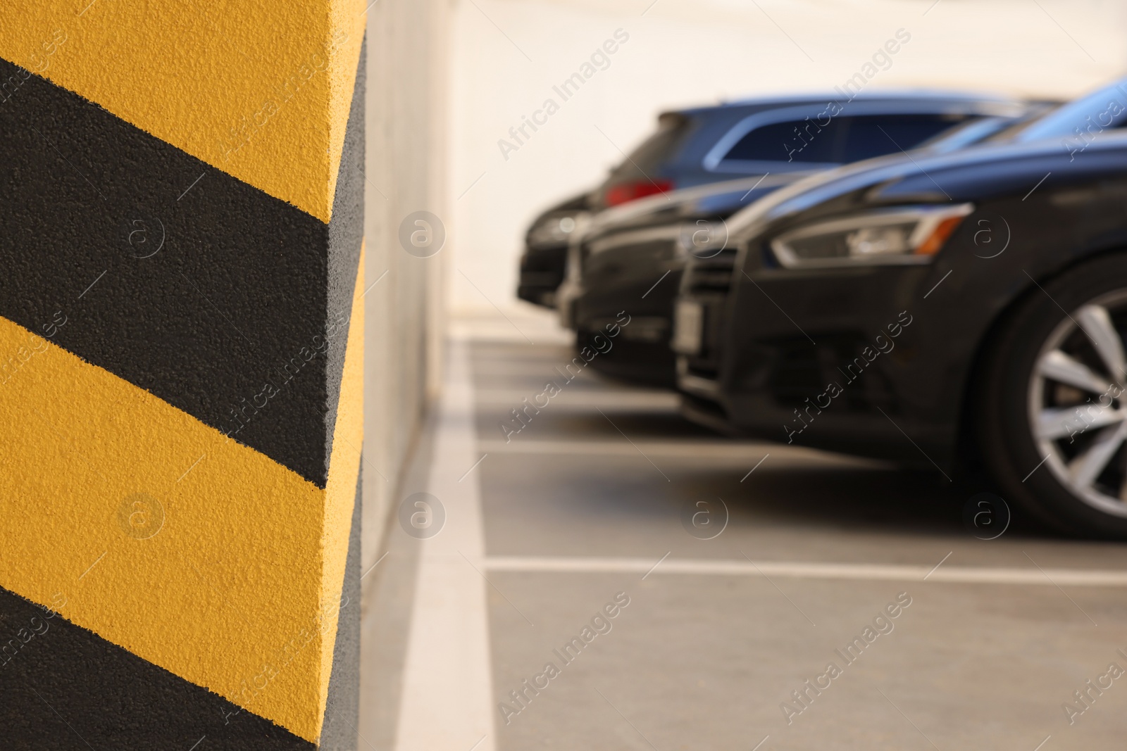 Photo of Outdoor parking lot, focus on column with warning stripes
