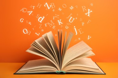 Open book with letters flying out of it on orange background