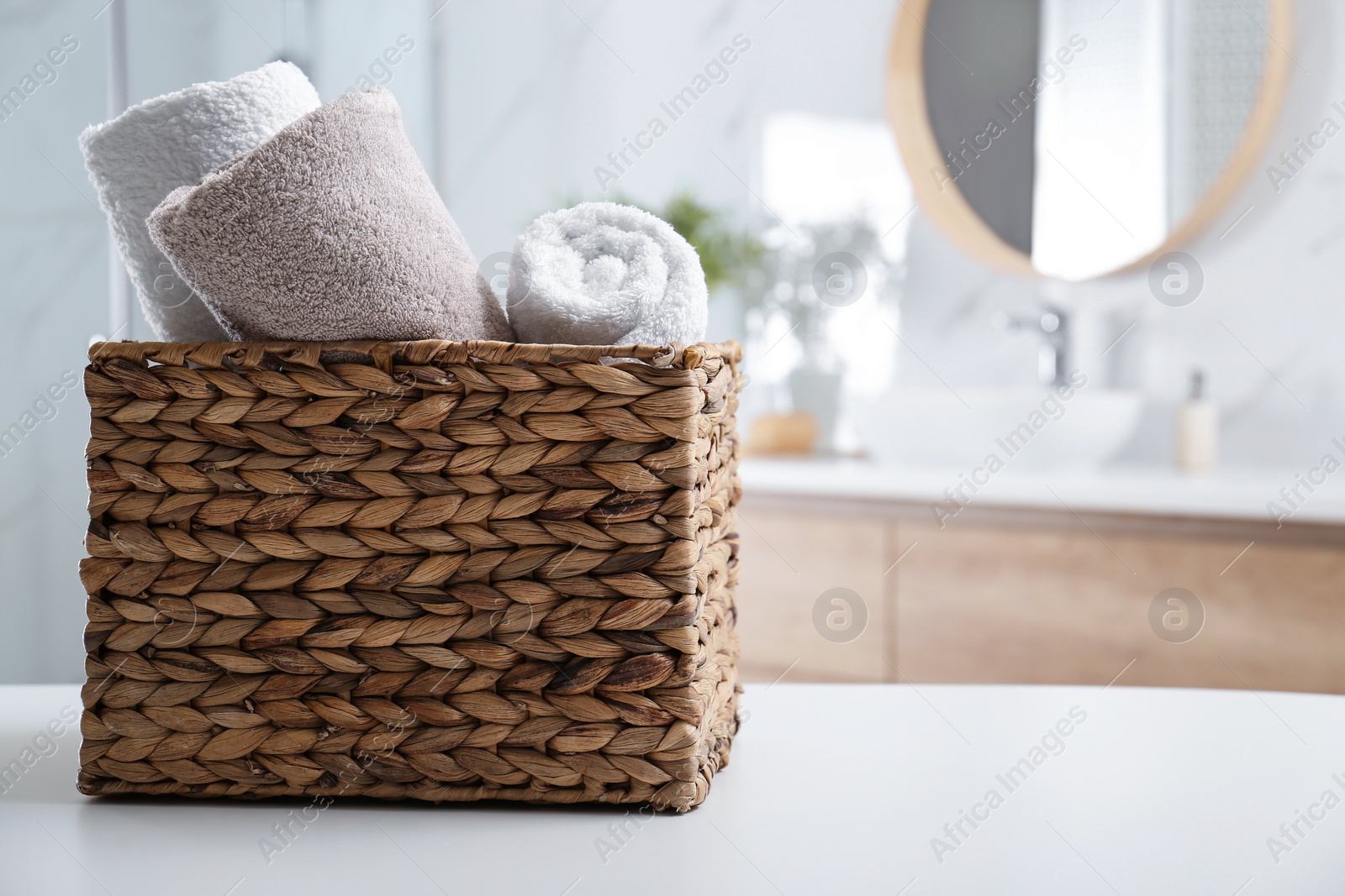 Photo of Wicker basket with clean soft towels in bathroom. Space for text