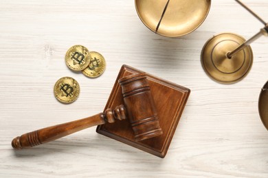 Law concept. Gavel, scales and bitcoins on white wooden table, flat lay