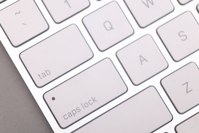 Internet shopping. Computer keyboard on grey background, top view